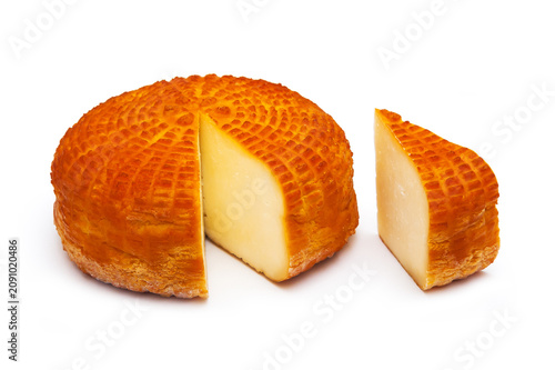 Piece of fresh homemade smoked cheese with a slice on a white background. Side view.