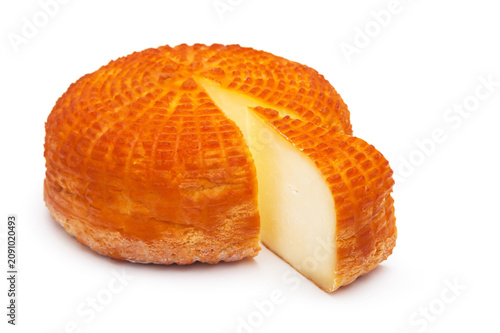 Piece of fresh homemade smoked cheese with a slice on a white background. Side view.