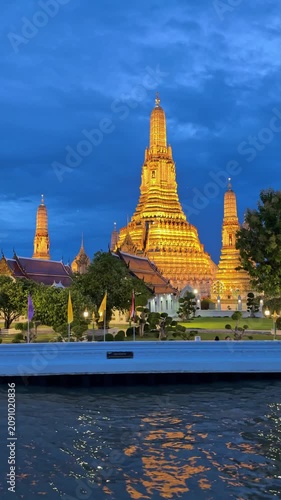 Sailing past Wat Arun temple at twilight on the Chao Phraya River