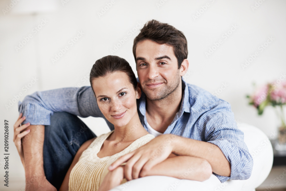Fototapeta premium Portrait, relax and care with couple on sofa for romance, bonding or support together. Calm, smile and relationship with man and woman in living room of home for marriage, happiness and loyalty