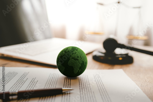 Green Earth with a judge's gavel symbolizes environmental law, sustainability, global responsibility, climate policy, and legal protection
