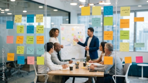 View through glass, office team brainstorms using a glass wall covered with sticky notes. Concept of teamwork, collaboration, idea generation, office productivity, creative processes. Generative AI