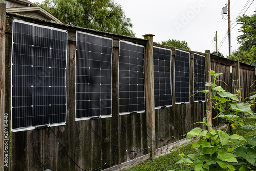 Fotografie Flexible solar panels installed on residential backyard fence extrapolated to ut