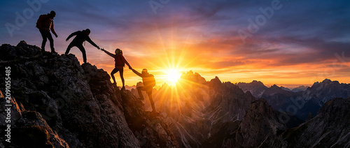 Team of brave hikers helping each other up a mountain at sunset perfect for showcasing strong leadership teamwork and outdoor adventures