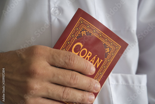Person is holding the coran, the holy book of islam