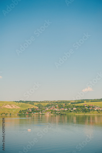 Peaceful river with green hills surround village