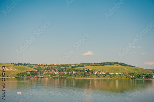 Peaceful river with green hills surround village