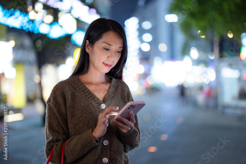 Woman using smartphone at night street