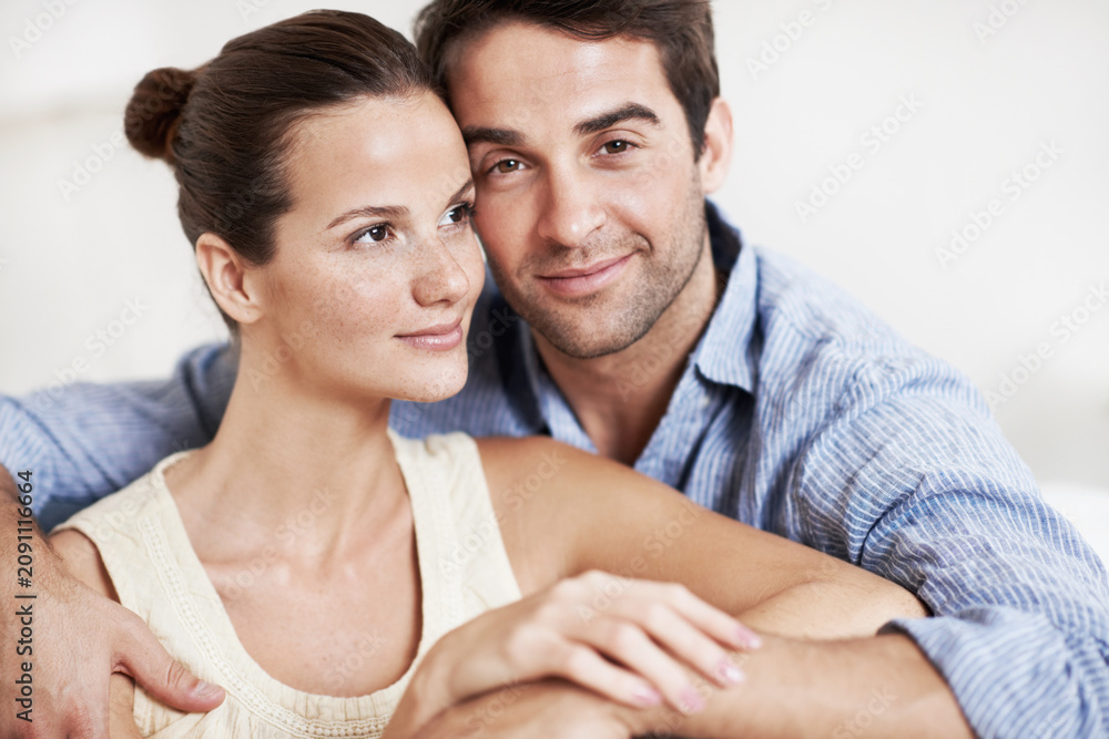 Fototapeta premium Love, relax and care with couple on sofa in home for bonding, support and weekend break. Happy, connection and commitment with portrait of man and woman in living room for marriage and loyalty