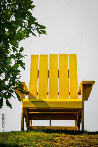 Giant yellow Adirondack Cape Cod chair at the Riverfront Park hilltop green overlooking Middlebury Falls in Middlebury, Addison County, Vermont, United States of America