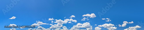 Rows soft steam stretch forming a striking natural pattern. Cloud layers moving dynamically right to left. Cumulus clouds clusters warm summer day vast blue sky. Large copy space above for writing.