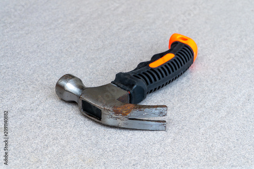 Rusty claw hammer with rubber grip handle on gray background
