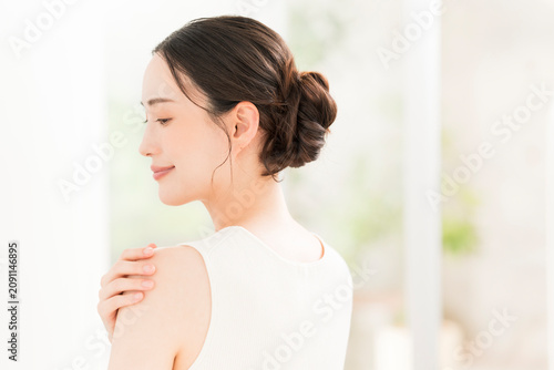 肩に手を添えて微笑む美しいアジア女性の横顔と後ろ姿