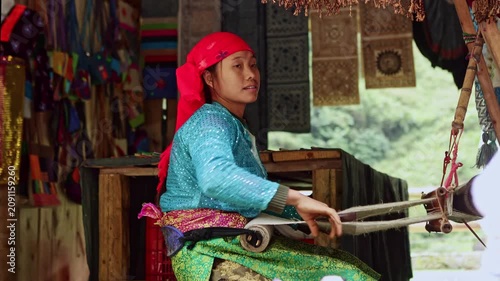 Vietnamese artisan woman weaving traditional fabric on loom