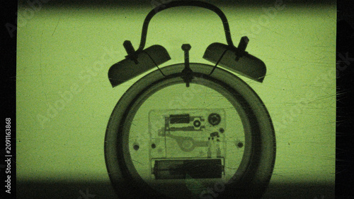 the process of creating an X-ray image of a mechanical watch with an alarm clock, captured on camera