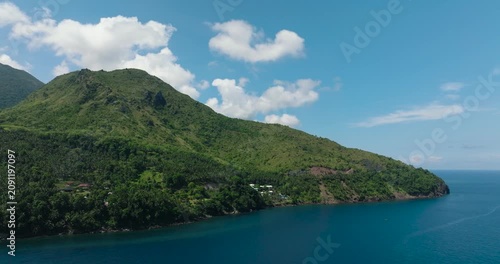 Mountain cliff near the coast. Blue sea in Camiguin Island. Philippines.