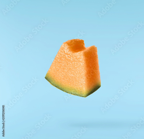 фотографія Flying fresh raw ripe cantaloupe melon isolated on a light blue background