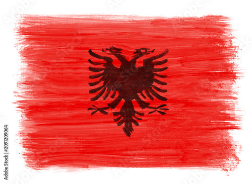 A hand‑painted Albanian flag with expressive ink strokes creates a bold, textured artistic composition.