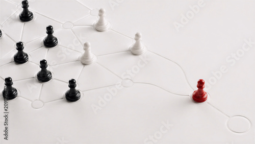 Red chess pawn separated from connected group on network path for leadership and individuality concept