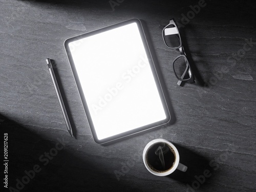 Minimal workspace flat lay with tablet coffee and eyeglasses on dark desk