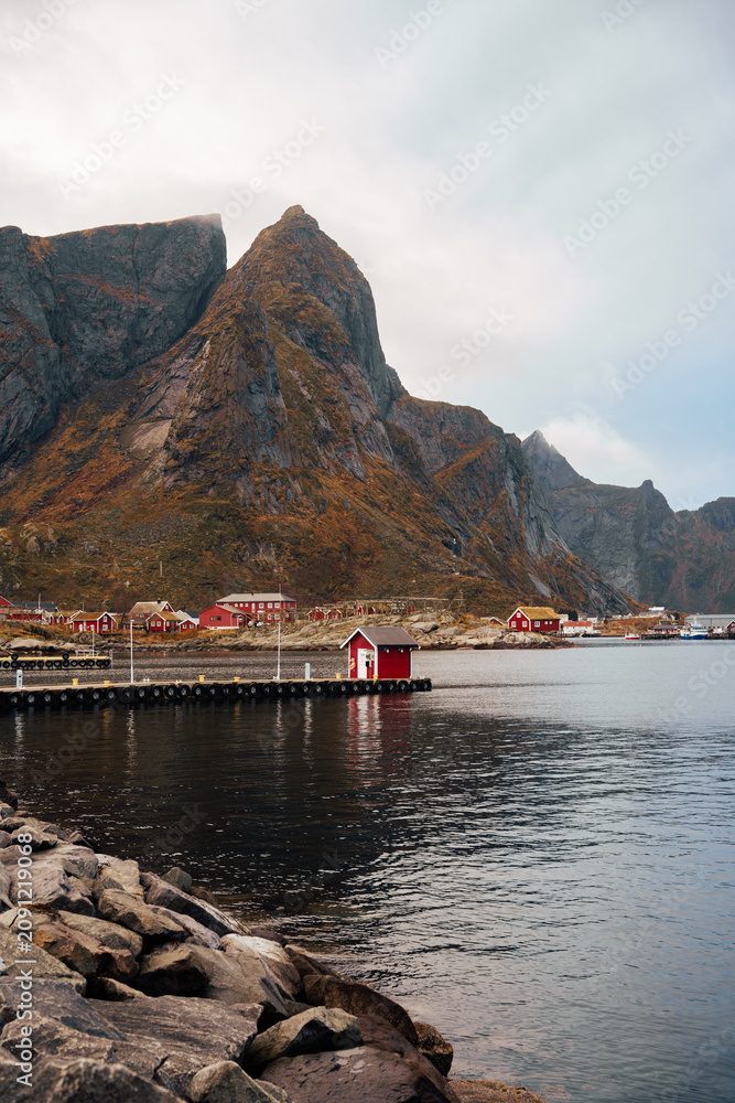 Fototapeta premium Mountain fjord harbor with red cabins and calm water