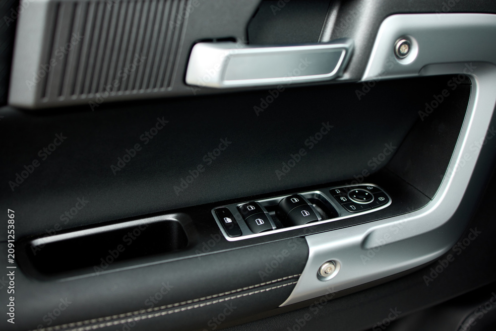 Obraz premium close-up of sleek modern car interior door panel with leather and plastic accents in a vehicle setting, showcasing a clean and contemporary design for automotive accessories.