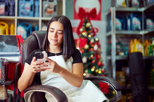 Fotografía Young hispanic female entrepreneur or small business owner using her smartphone