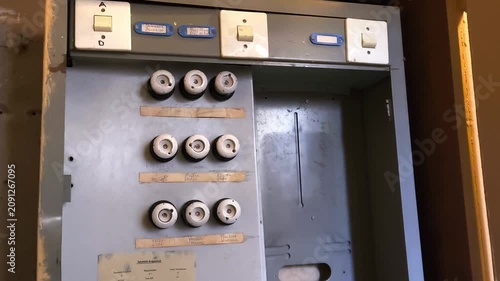 Vintage electrical fuse box with ceramic screw-in fuses on an old wall