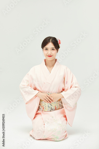 Quadro su tela Young Woman Sitting in Traditional Pink Kimono
