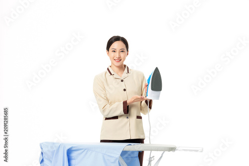 Konstfotografi Housekeeping worker holding iron beside ironing board on white background