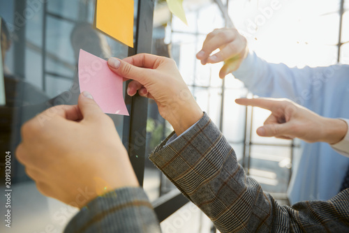 hand glues empty sticker on office window.