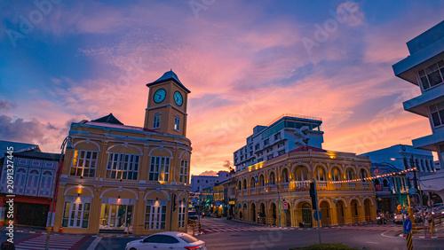 Beautiful Twilight Cityscape of Phuket Old Town Thailand. Vibrant sunset scenery over the landmark clock tower in Phuket with illuminated heritage buildings and bustling city traffic during blue hour