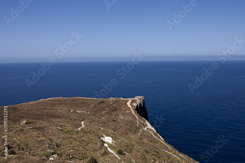 Canvastavla High angle view of a rocky cliff cape with walking paths ending in the blue sea in Malta