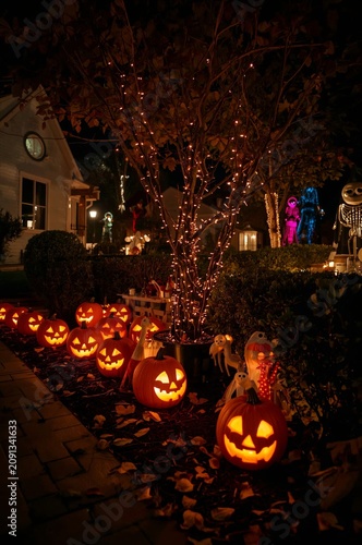 Halloween Night With Carved Pumpkins and Lights in a Neighborhood Garden