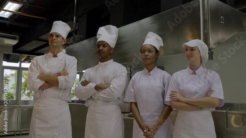 Chefs stand together in commercial kitchen preparing for cooking lesson