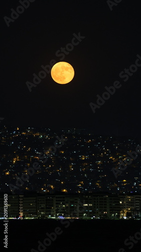 Moon Rising Over City Skyline