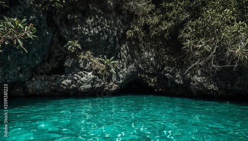 Calm Waters Reflect Bright Blue Sky Near Rocky Cliffs in Coastal Area