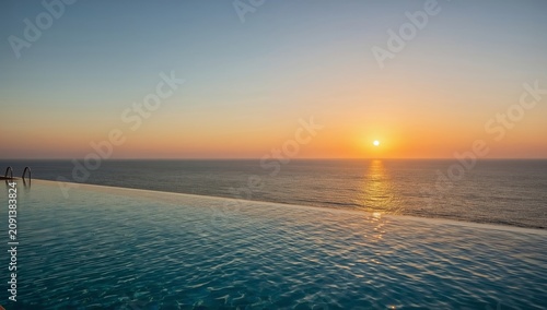 Sunset Over a Calm Ocean With an Infinity Pool in View Near a Beach Location