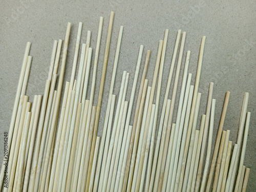 Fotografie A row of blunt bamboo stalks against a brown paper background.