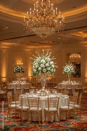 Elegant Event Space With Floral Arrangements and Chandeliers Set for a Specia...