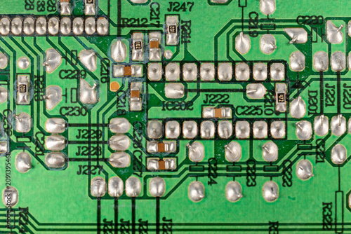 Close-up of electronic pathways and soldering points. Detailed information on printed circuit board technology. Copper traces on the substrate,