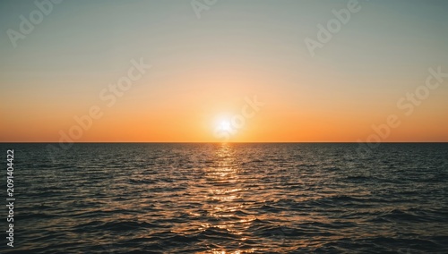 Sunset Over the Ocean With Clear Sky and Waves at the Horizon