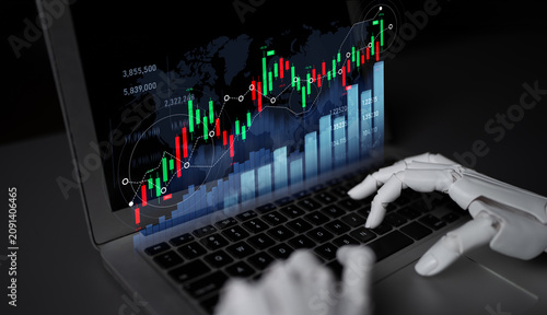 Fotografie A robotic hand explores a laptop screen filled with vibrant stock market graphics, showcasing the blend of technology and finance in modern investment strategies
