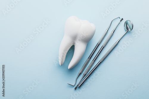 Dental Tools and Tooth Model on Blue Background for Oral Care and Dental Clinic Use