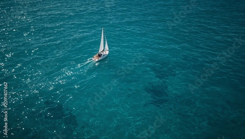 Sunny Day on the Water With a Sailboat Gliding Over Clear Blue Sea Waves