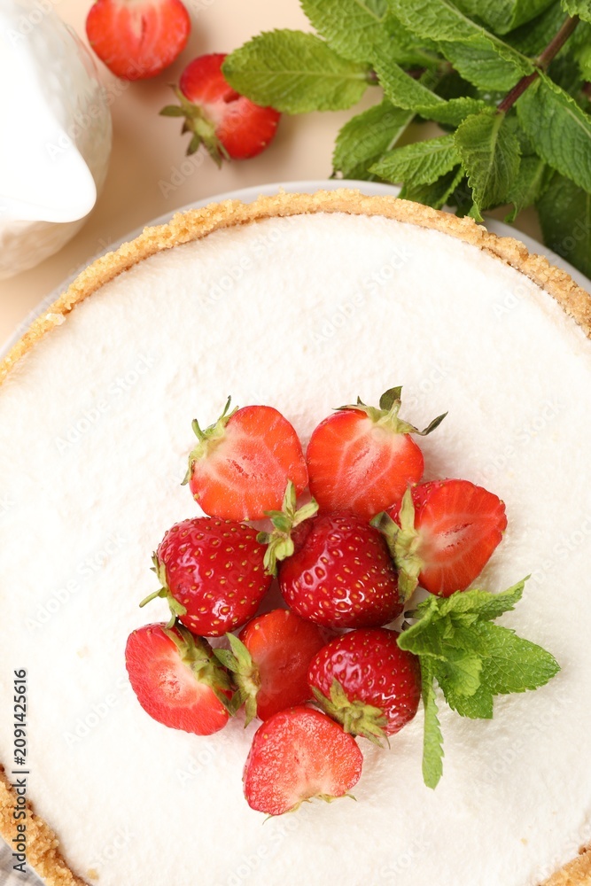 Obraz premium Yummy cheesecake with strawberries and mint on beige table, flat lay