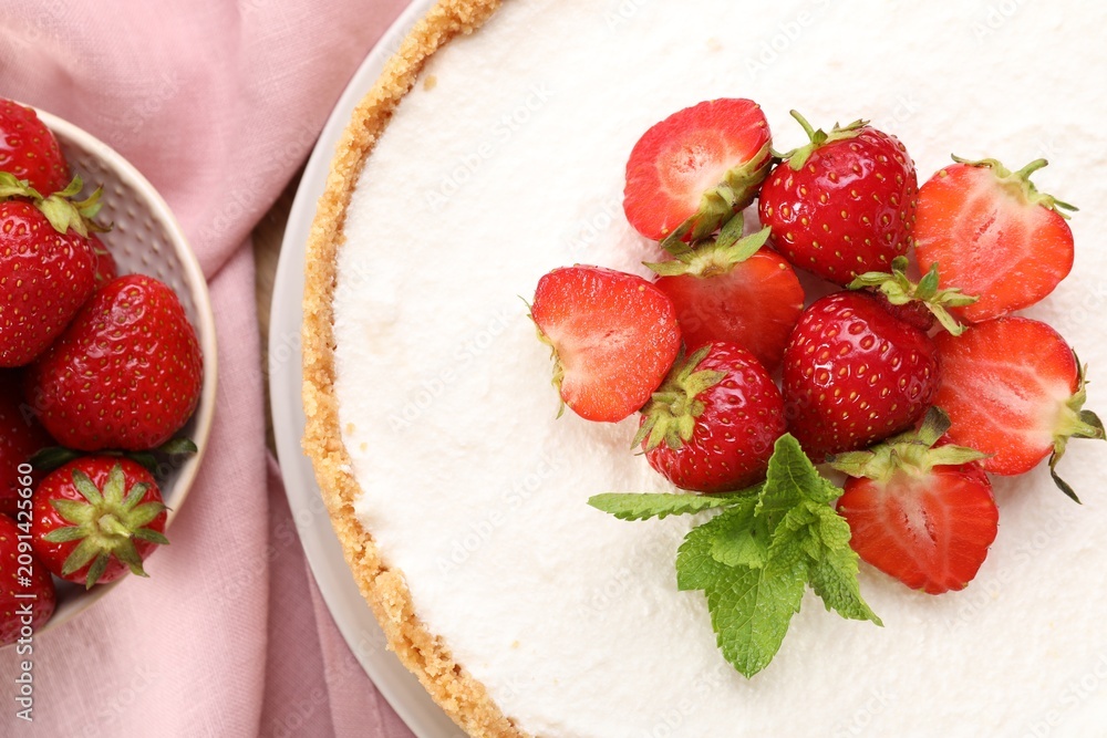 Obraz premium Yummy cheesecake with strawberries and mint on table, flat lay