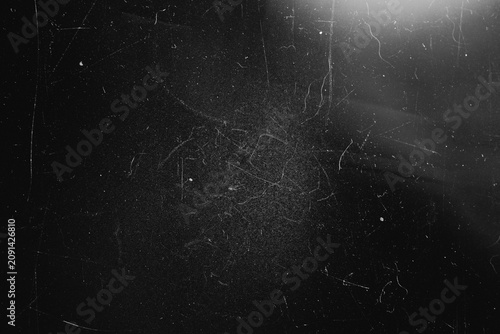 Distressed black texture background with heavy center scratches and top right lens flare
