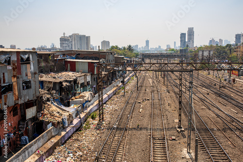 Photos Railway tracks adjacent to a slum area with modern skyline in Mumbai