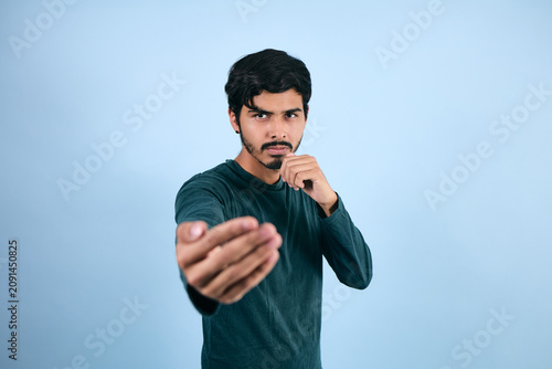 Schilderij op canvas portrait of young latin man in fighting pose on blue background in Mexico Latin